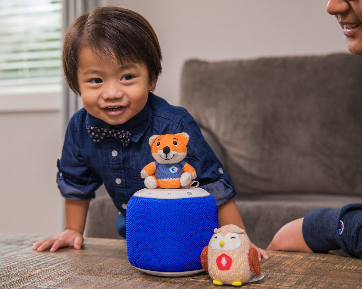 1-year-old boy plays with a Storypod and Carfties at the coffee table with his father. It is important to engage with your child at this age in order to encourage social development.