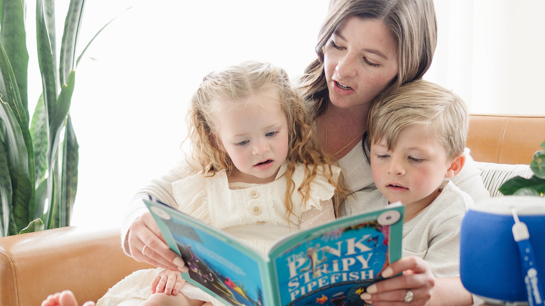 A mom, her daughter and son enjoying a read-along audiobook on their Storypod