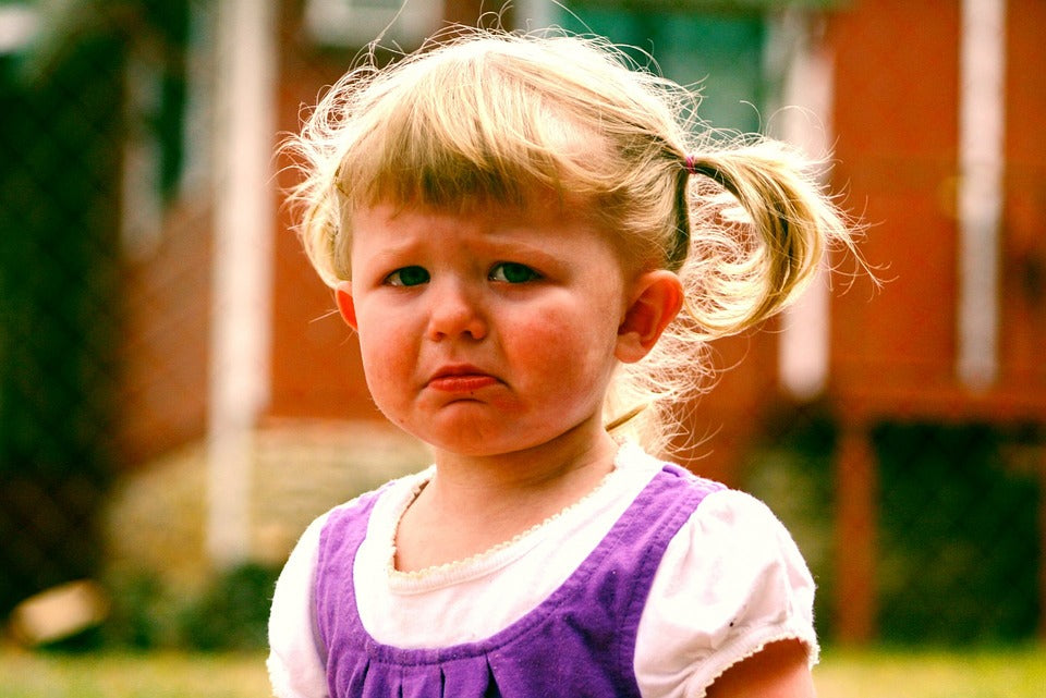 3-year-old girl wears an expression of tearful sadness on her face. Tantrums are normal part of the toddler phase and must be managed properly in order to develop emotional regulation in your child.