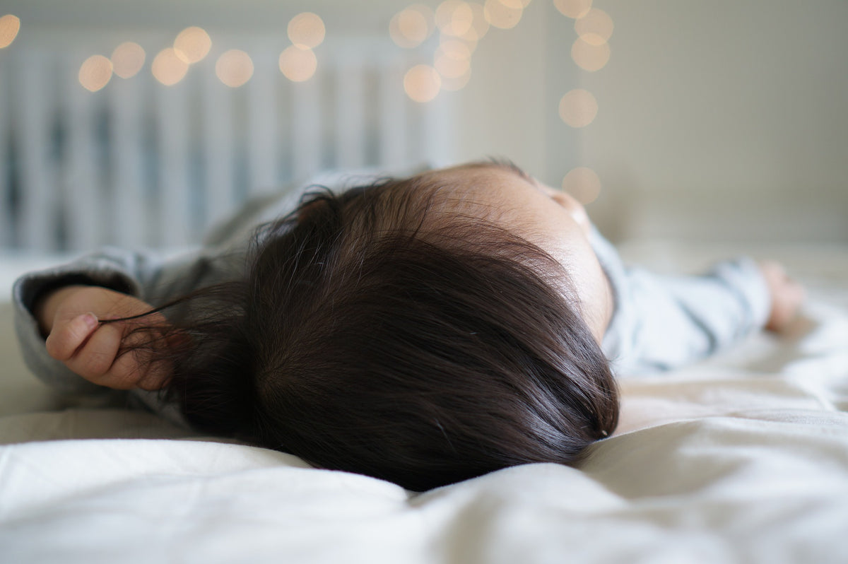 Baby boy sleeps peacefully. Transitioning your 1-year-old from co-sleeping can be a challenge, but is achieved through consistency and patience.