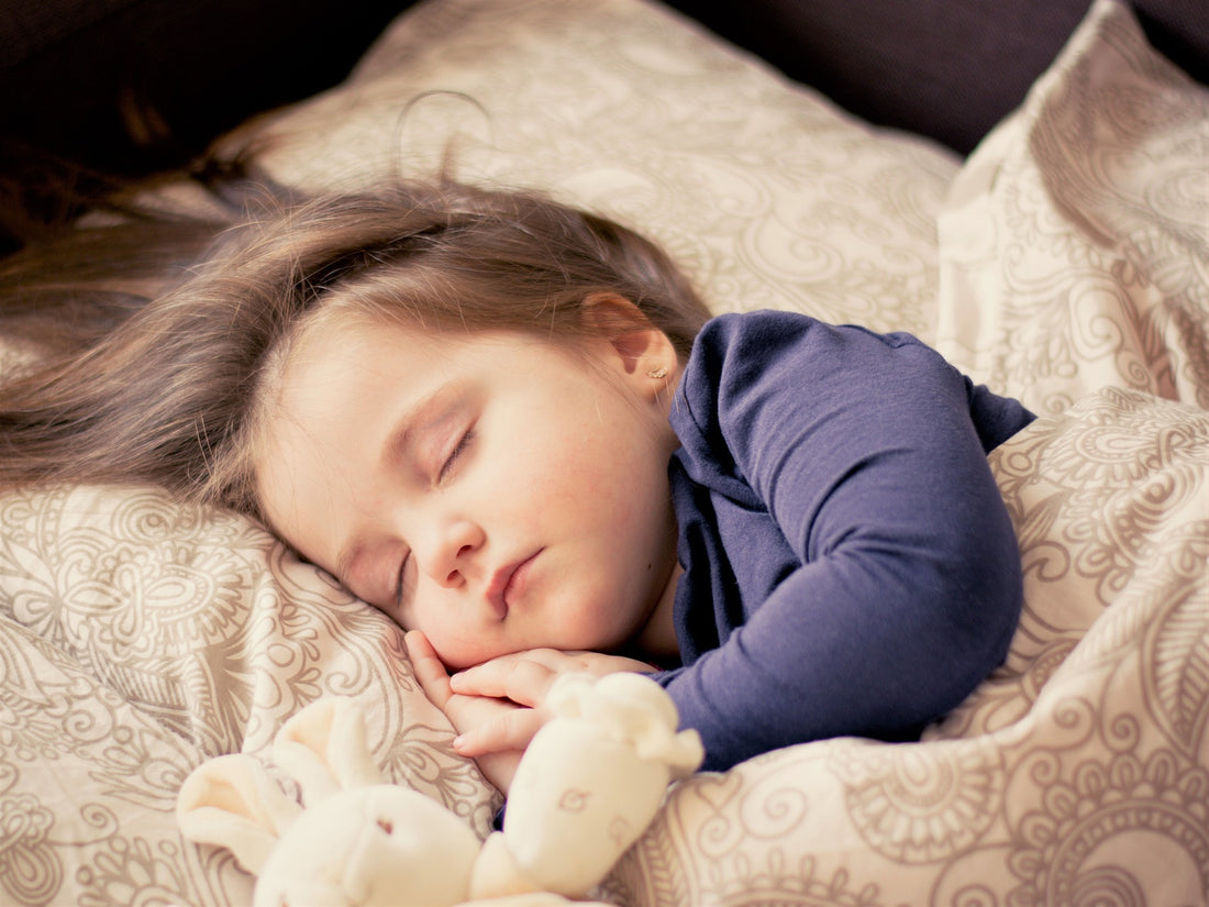 Young child sleeps peacefully next to stuffed bunny