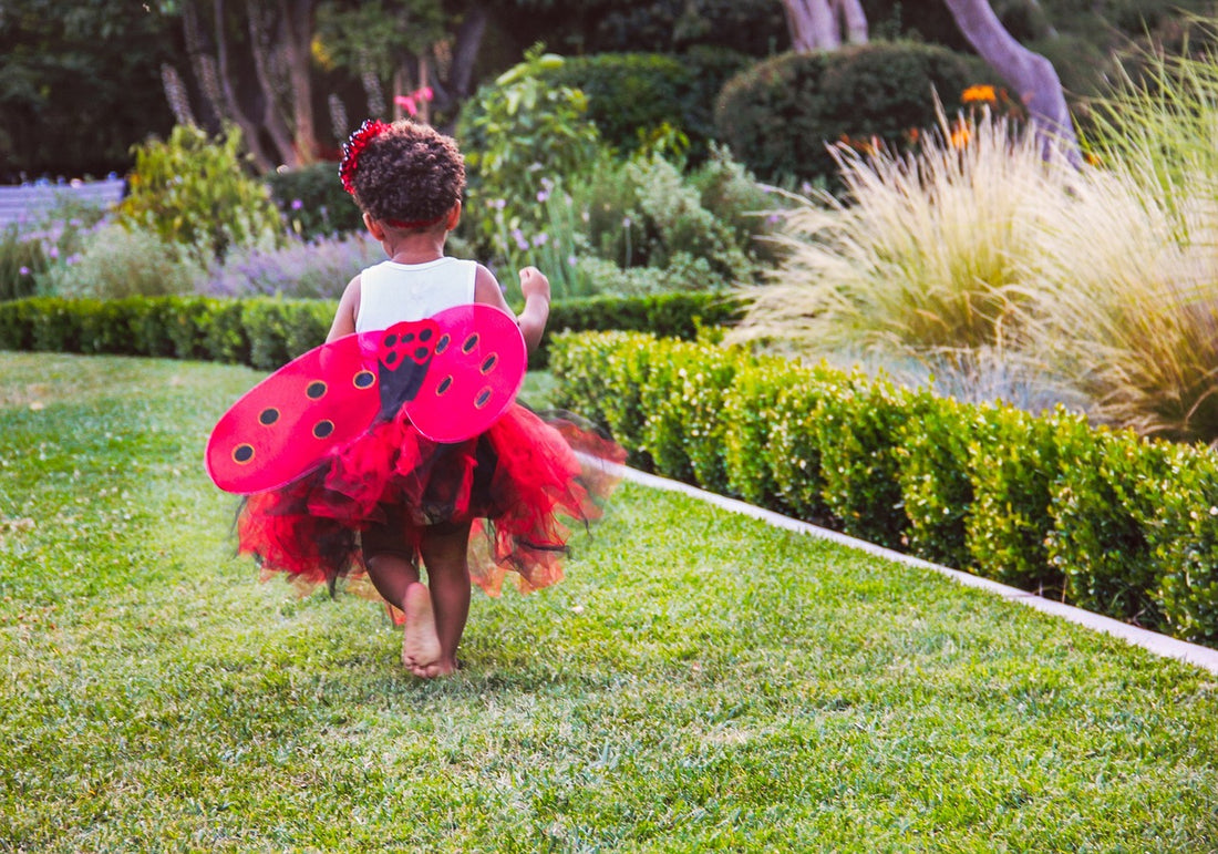 3-year-old girl in a ladybug costume runs across a grassy lawn. At 3 years of age, your child is continuing to develop their gross motor skills such as running, jumping, and climbing.