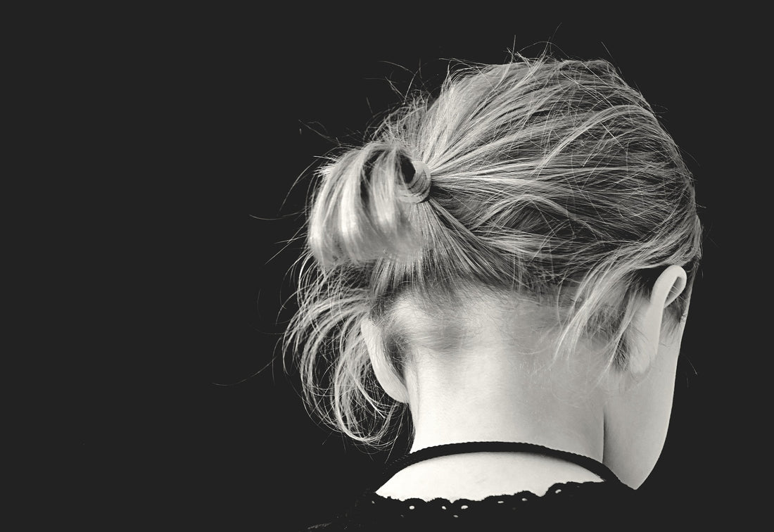 Black and white photo of the back of a 2-year-old girl's slightly bowed head. Timeout is an effective method of discipline at this age, if done correctly.