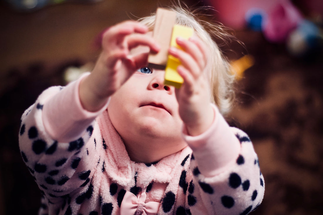 Toddler holds up blocks to see if they match. Matching and sorting are two important cognitive skills for young children to learn.