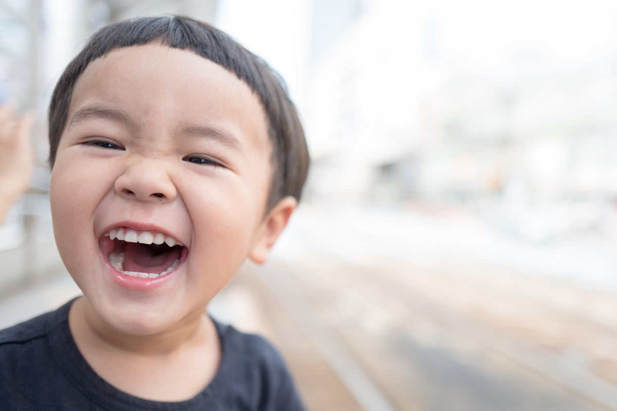 4-year-old boy gives a big smile. Nurturing your child's communication skills through questions and praise is important.