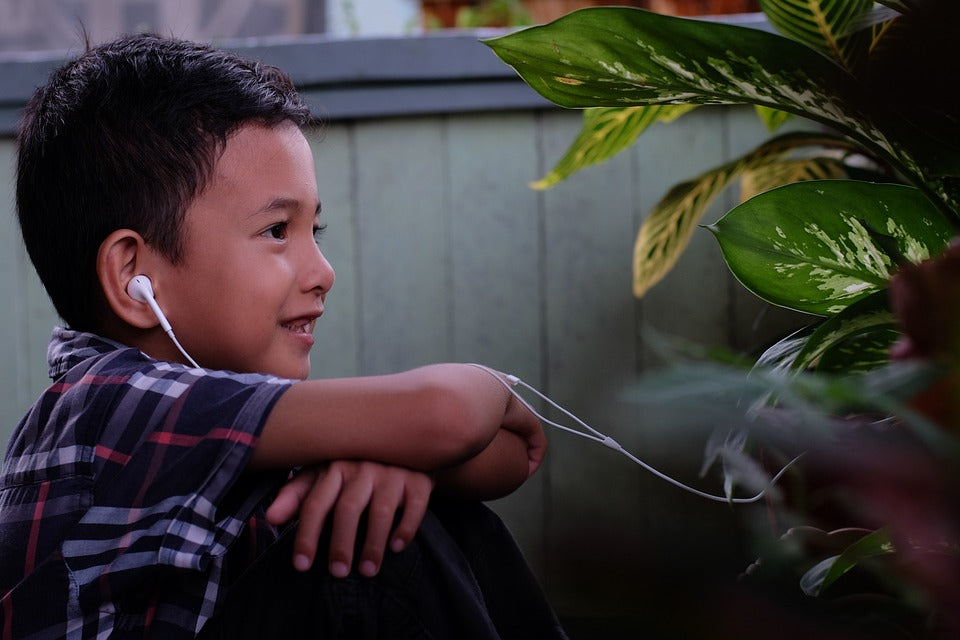 4-Year-Old boy listens to an audio book with headphones. There are many fun ways to practice active listening skills!