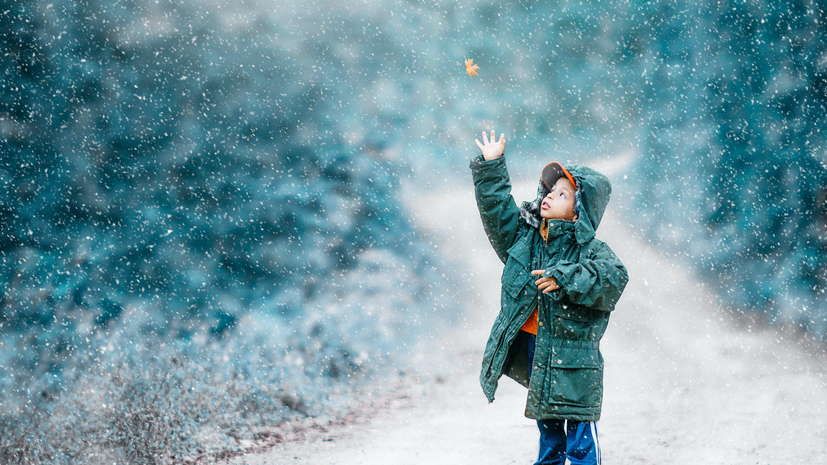 Little boy celebrates winter solstice with a walk in the snow.