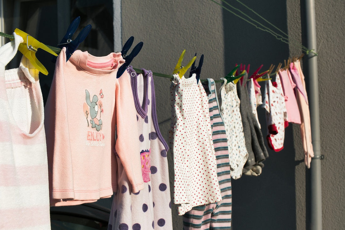 An array of children's clothes hand outside on a line to dry. Teaching your children to dress themselves early is a great way to start facilitating their independence.