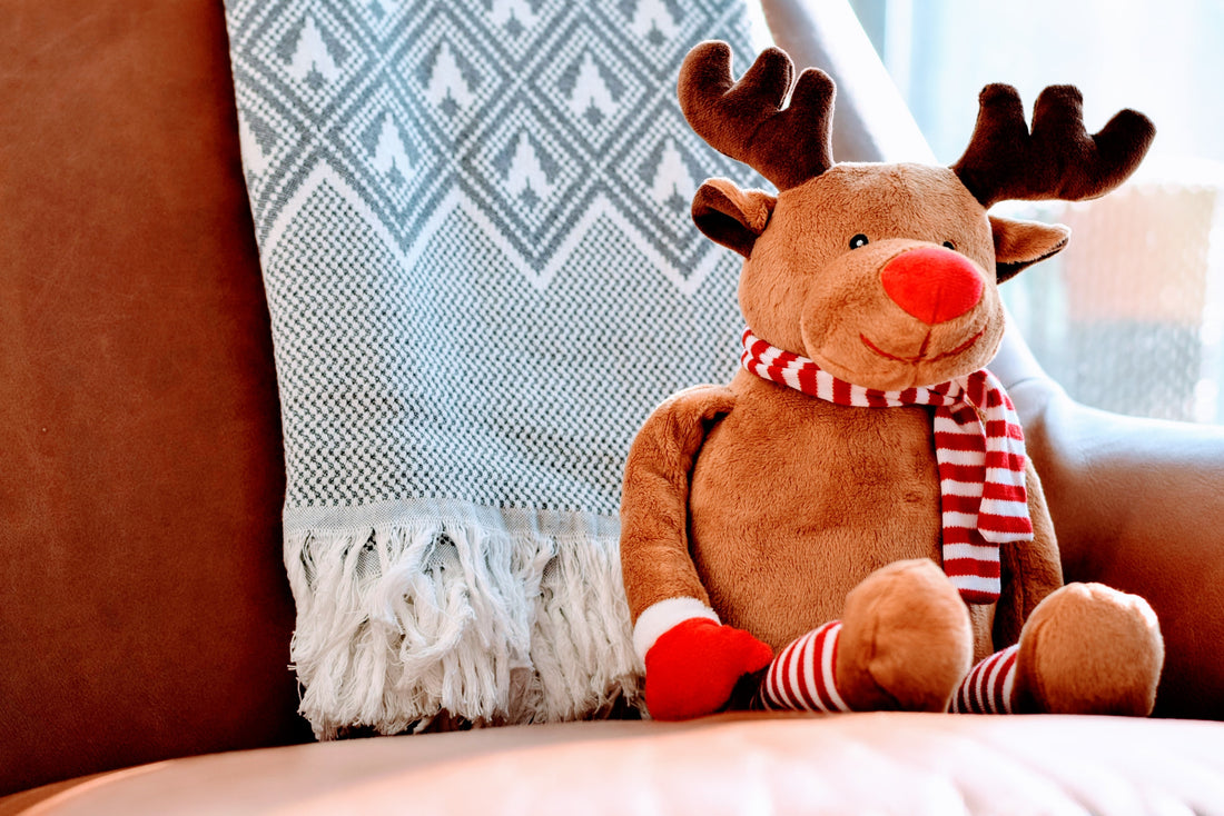 Happy, stuffed reindeer sits on chair awaiting to be given as a gift.